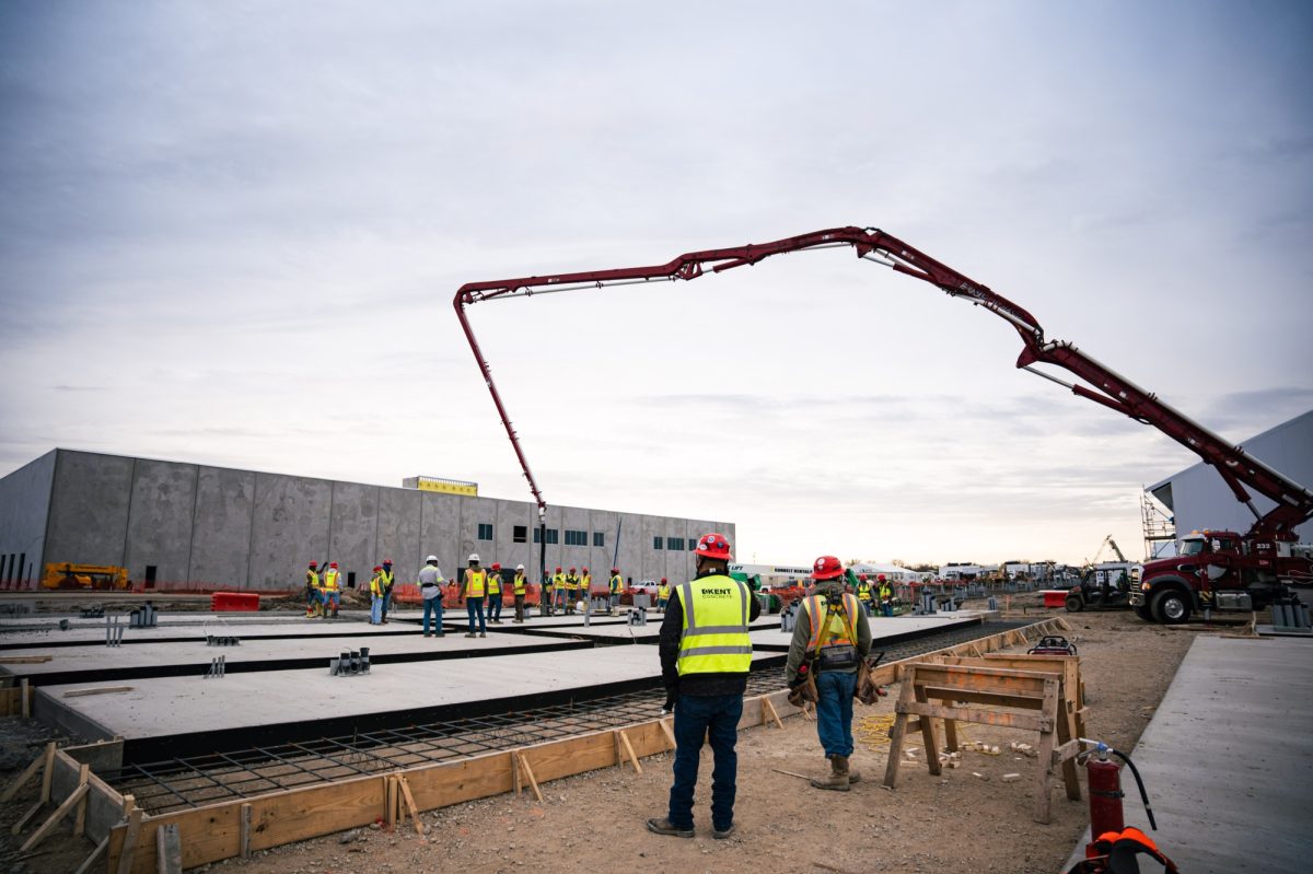 Construction pros in hi vis pouring concrete for data center